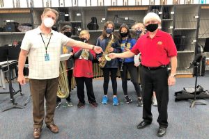 Venice Concert Band Treasurer Russ Bullis presents $2,000 grant to Pine View Middle School band director Victor Mongillo for an alto saxophone. February 2021.